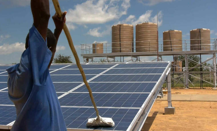 Worker cleans solar panels at a desalination plant in Akutsima, Namibia 工人在Akutsima,纳米比亚脱盐设备清洁的太阳能电池板
