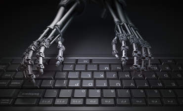 机器人用手在电脑键盘上打字，说明了自动化和人工智能的研究概念