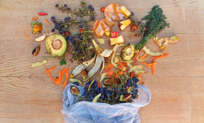 鸟瞰图的水果和蔬菜废物的堆肥在垃圾袋在桌上。