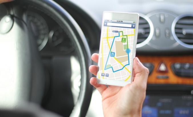 司机手持手机，手机屏幕上显示着地图