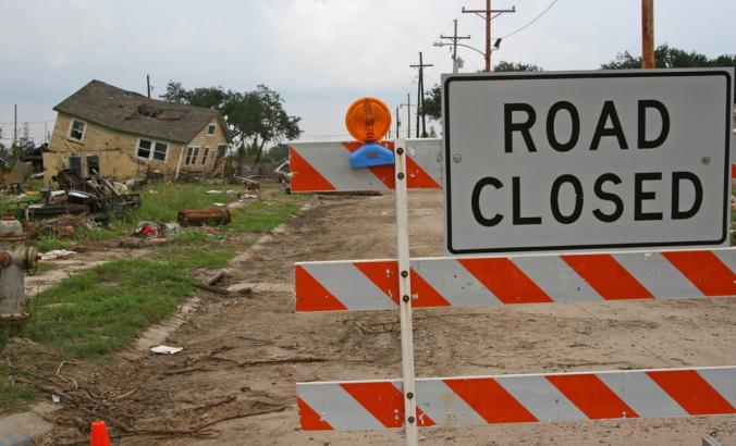 在卡特里娜飓风中,路易斯安那州新奥尔良第九区一处被废弃的房屋和其他废墟遭到破坏。“道路封闭”的标志阻止人们进入。