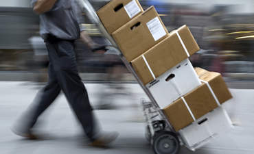 Delivery person with boxes on a dolly
