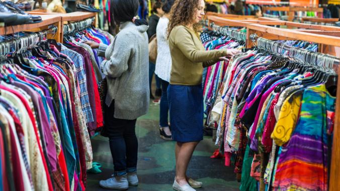 在旧货店里浏览衣服的顾客。