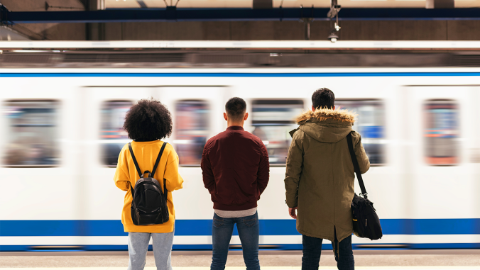 3 people in front of a subway going by